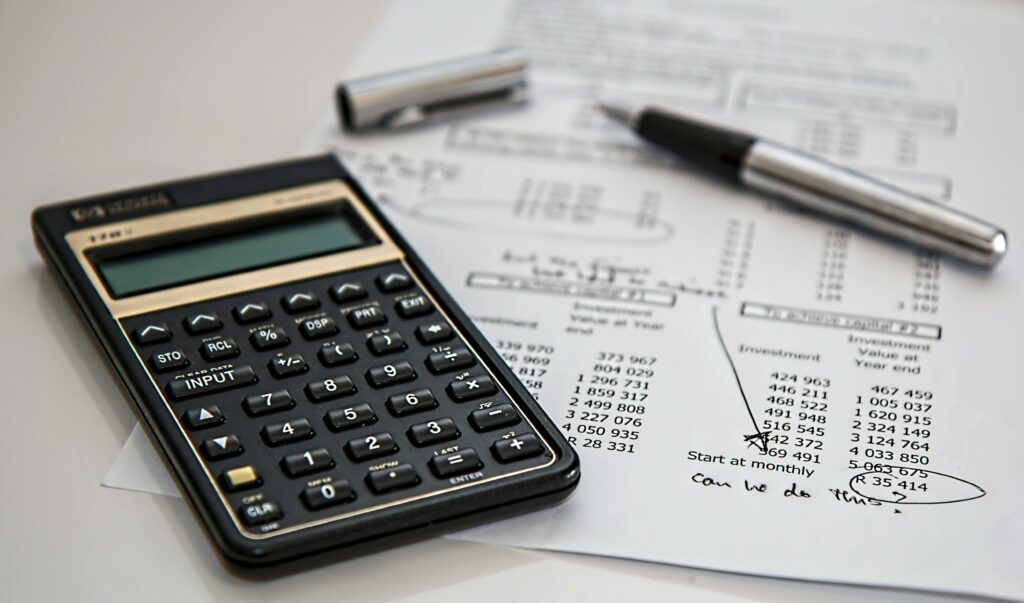calculator-calculation-insurance-finance-53621-53621 Close-up of financial documents with calculator and pen, ideal for business management themes.
