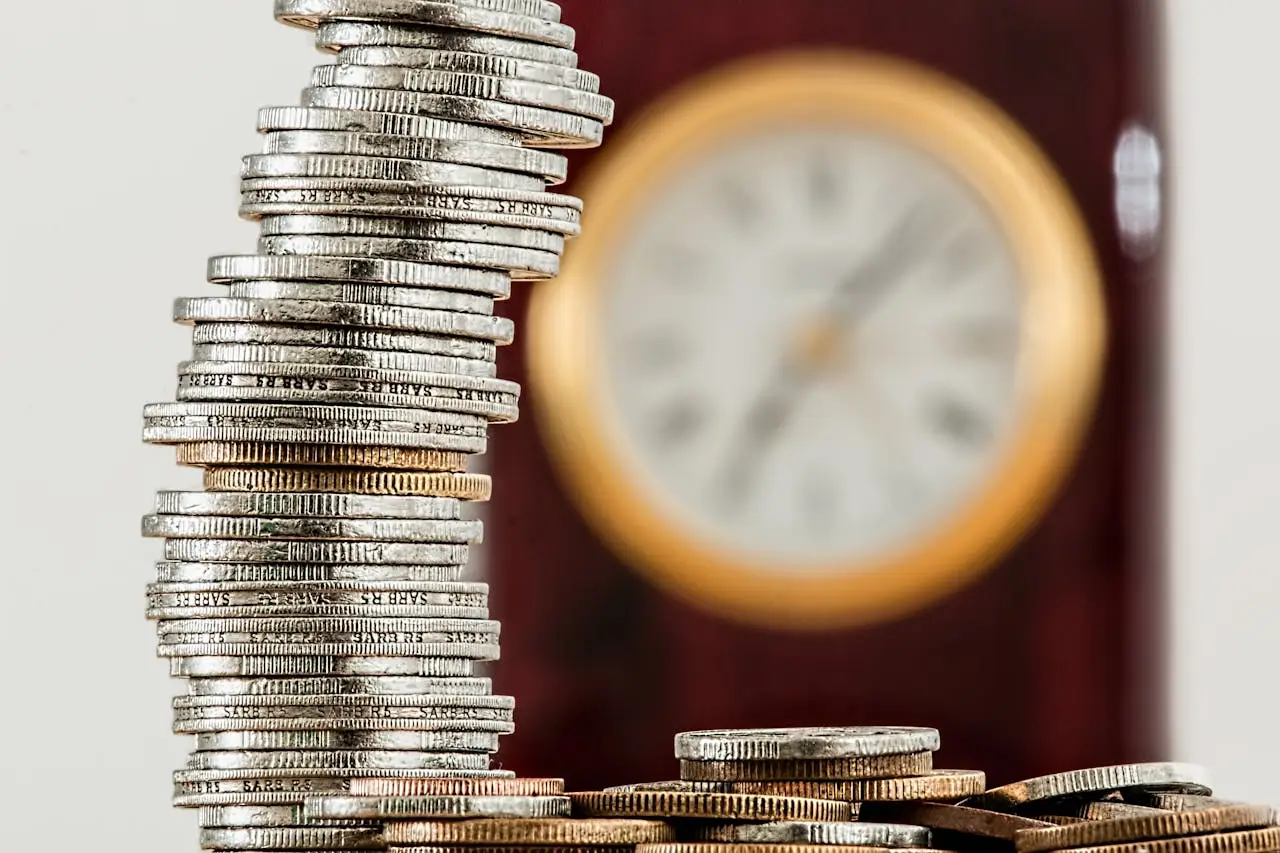 why-choose-us A close-up image of stacked coins with a blurred clock, symbolizing time and money relationship.